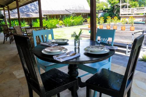 a table with plates and utensils on it at Chanteak Bali - Teak House 3 in Jimbaran