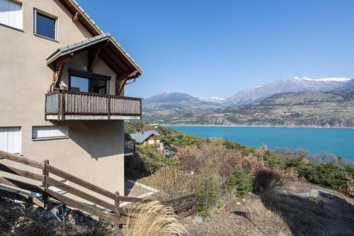 une maison sur une colline avec vue sur un lac dans l'établissement Le Bleuet du Lac, à Savines