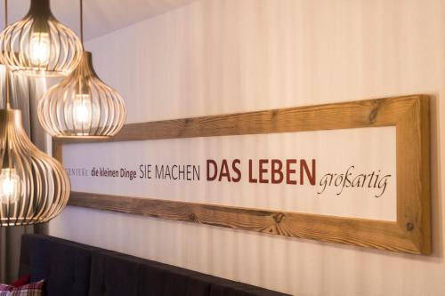 a sign on a wall with two lights and a picture at Hotel Apart Piz Mundin in Kappl