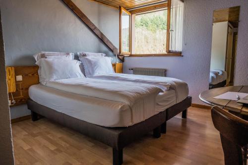 a large bed in a room with a window at Hôtel Au Vieux Moulin in Lapoutroie