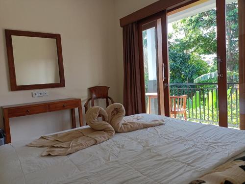 a bedroom with a bed with a towel on it at Diary home stay in Ubud
