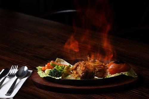 a plate of food with meat and vegetables on a table at Kantipur Village in Kathmandu