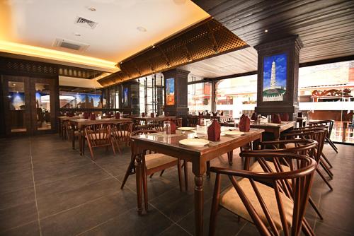 a restaurant with wooden tables and chairs in it at Kantipur Village in Kathmandu