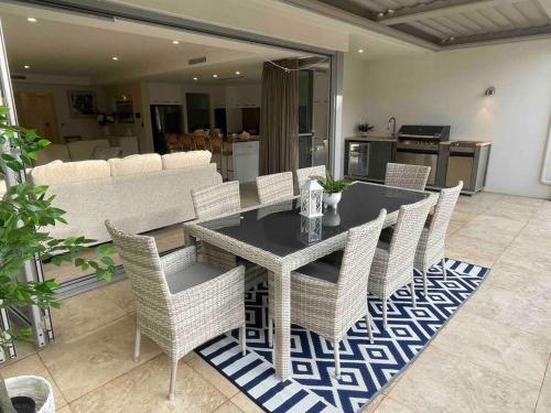 a dining room with a table and wicker chairs at Canal Vista in Mandurah