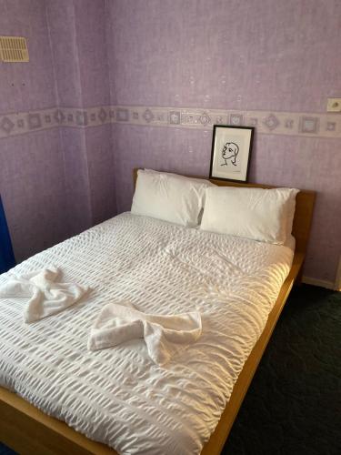 a bed with white sheets and two towels on it at 'Melrose' at stayBOOM in Lancaster