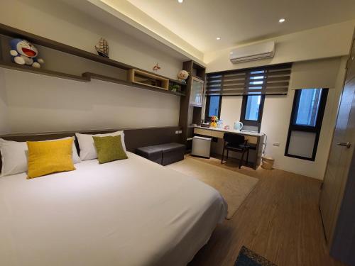 a bedroom with a large white bed with yellow pillows at Love Happiness Inn in Suao