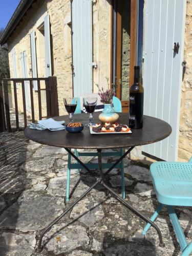 una mesa con dos copas de vino en un patio en Mas de Bruget en Catus