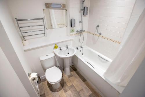 a bathroom with a toilet and a sink and a bath tub at The Waverley Hotel in Callander