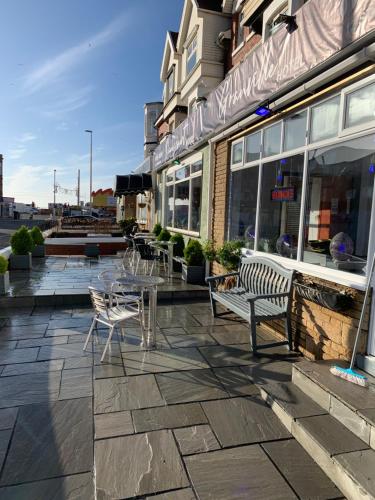 a patio with tables and chairs in front of a building at The Danescourt in Blackpool