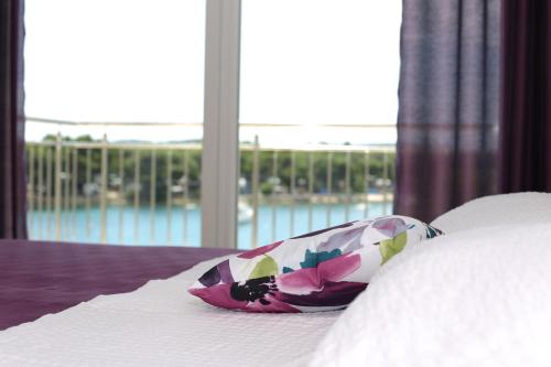 a pillow on a bed with a view of the water at Apartments Dado Trogir in Trogir