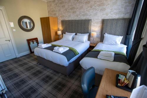 a hotel room with two beds and a table at The Waverley Hotel in Callander