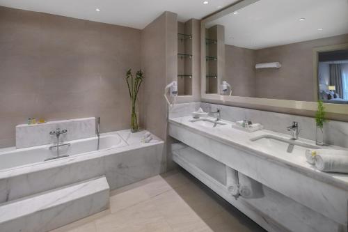 baño con 2 lavabos y espejo grande en Jaz Aquaviva en Hurghada