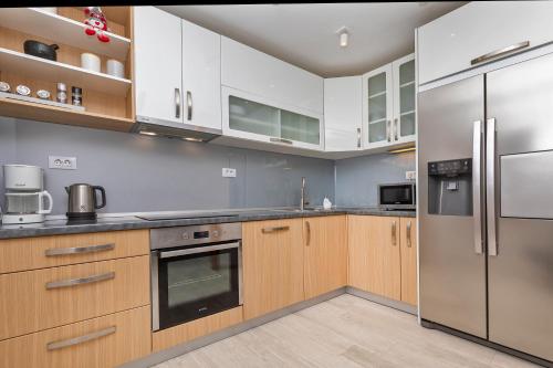 a kitchen with wooden cabinets and stainless steel appliances at Domino Holiday Home in Dubrovnik