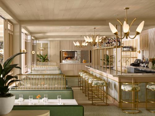 a restaurant with green and gold stools and a bar at PGA National Resort in Palm Beach Gardens