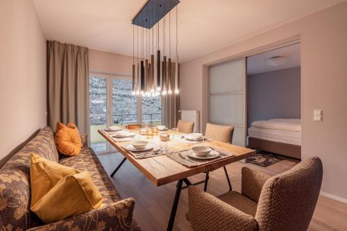 a dining room with a table and a couch at FOREST Private Suites in Titisee-Neustadt