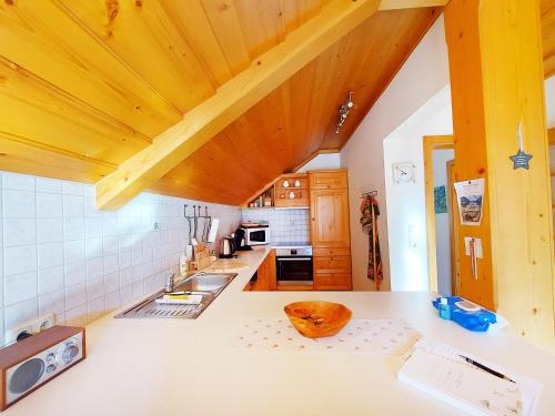 a kitchen with wooden ceilings and a counter with a sink at Haus Annerl in Grundlsee