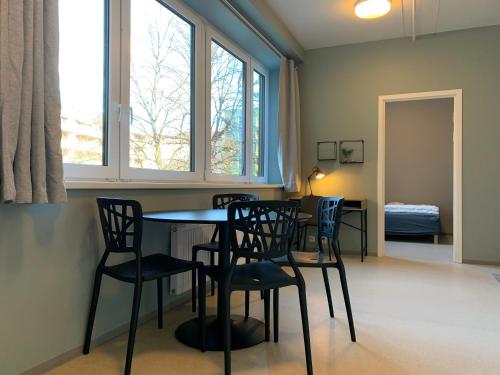 a dining room table with chairs and a window at Anker Apartment – Grünerløkka in Oslo
