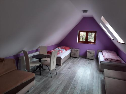 a attic room with two beds and a table at Pokoje gościnne w centrum in Bogatynia