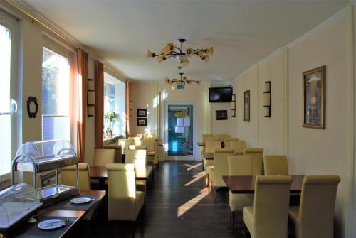 Hotel am Bahnhof في فايلبورغ: مطعم فيه كراسي وطاولات وغرفة طعام