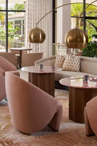 a lobby with couches and tables and windows at PGA National Resort in Palm Beach Gardens