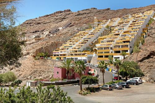 a parking lot with cars parked in front of a mountain at Suite On the Beach in Playa del Cura