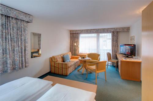 a hotel room with a bed and a living room at Hotel Metropol & Spa Zermatt in Zermatt