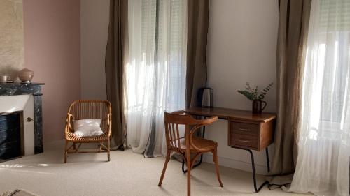 a desk and chair in a room with a window at Chambres d'hôtes - La Maison 19 in Niort