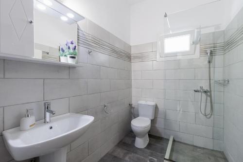 a white bathroom with a sink and a toilet at Katerina Horizon Apartments by Konnect - 1,8km from Ipsos beach in Ýpsos