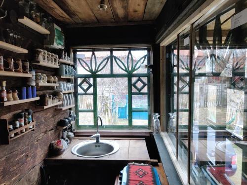 a bathroom with a sink and a large window at Casa Padureana - Log House from 1860 in Hunedoara