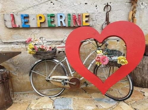 um coração vermelho pendurado numa bicicleta com cestos em Le Perine 6 em Valdobbiadene
