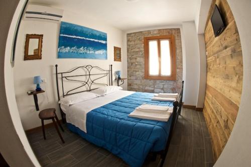 a bedroom with a blue bed and a window at Le Perine 6 in Valdobbiadene