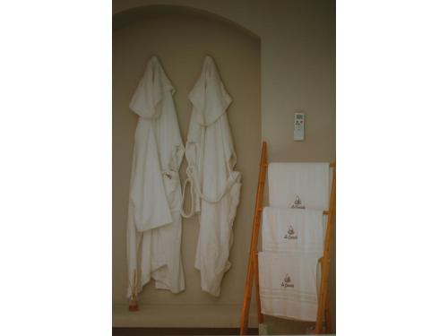 un grupo de toallas blancas colgando en una pared en Le coccole luxury Suite en Sannicandro di Bari