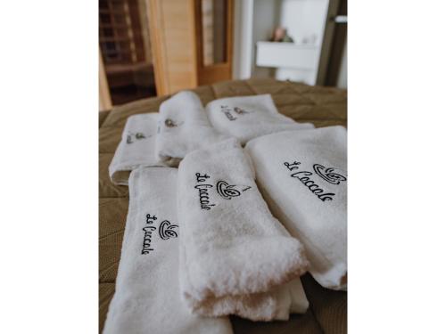 eine Gruppe weißer Handtücher auf einem Bett in der Unterkunft Le coccole luxury Suite in Sannicandro di Bari