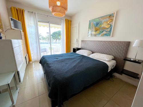 a bedroom with a bed in a room with a window at L'appartement Royal Palm in Cannes