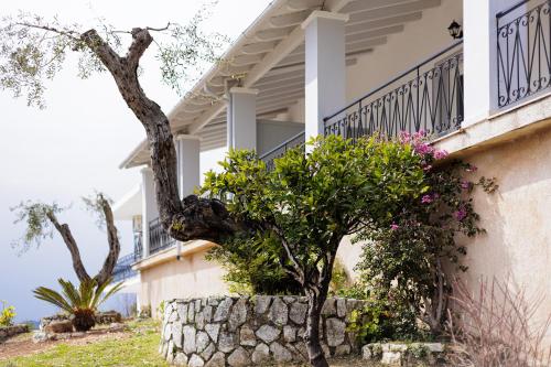 a house with flowers on the side of it at Katerina Horizon Apartments by Konnect - 1,8km from Ipsos beach in Ýpsos