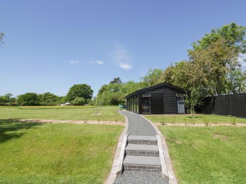 a garden path leading to a black shed at The Tractor Shed in Worcester