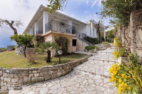 a house with a stone walkway in front of it at Katerina Horizon Apartments by Konnect - 1,8km from Ipsos beach in Ýpsos