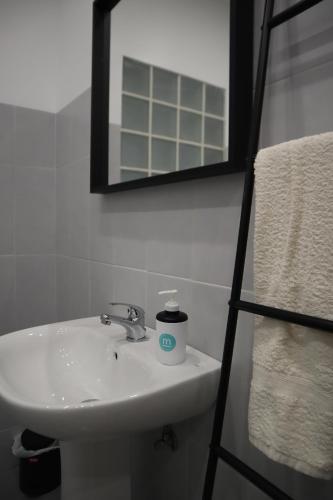 bagno con lavandino bianco e specchio di The Minimal House a Bombarral