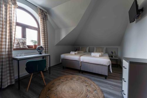 a attic bedroom with two beds and a window at Hotel Do Poduchy in Zawiercie