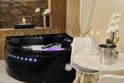 a bath tub in a room with a table at Suite Paradise Rome Guest Rooms in Rome