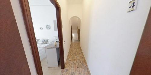 um corredor que leva a uma casa de banho com espelho em Stella Maris Marzamemi Apartments em Marzamemi