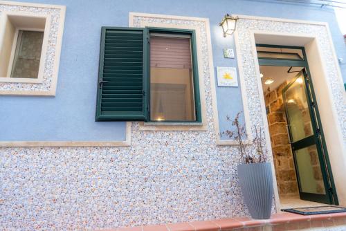 a blue building with a window and a vase at Stella Maris Marzamemi Apartments in Marzamemi