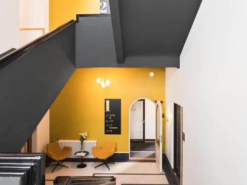 een trappenhuis met gele muren en oranje stoelen bij DuoStay in Tartu