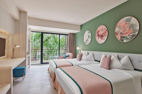 2 Betten in einem Zimmer mit grünen Wänden in der Unterkunft Caesar Park Hotel Kenting in Kenting