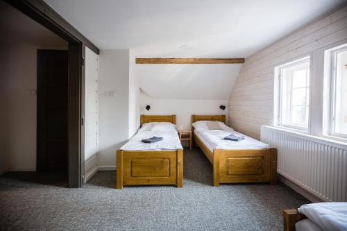 two twin beds in a room with two windows at Turnovská chata in Kořenov