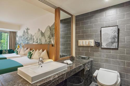 a hotel room with a sink and a bed at Caesar Park Hotel Kenting in Kenting