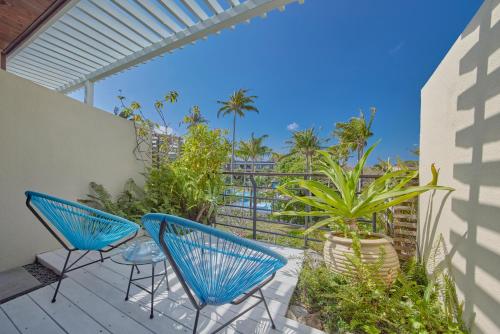 a patio with blue chairs and plants on a balcony at Caesar Park Hotel Kenting in Kenting