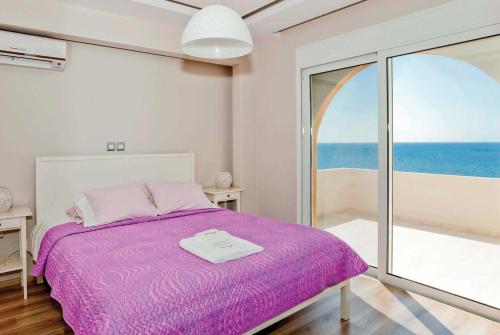 キオタリにあるParadise Beachの海の景色を望むベッドルーム1室(紫色のベッド1台付)