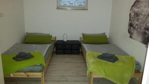 2 camas individuales en una habitación con sábanas verdes en Zimmervermietung Bully, en Meyenburg
