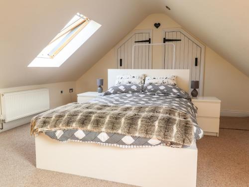 um quarto com uma cama e uma clarabóia em Old Spot Cottage em Goodwick